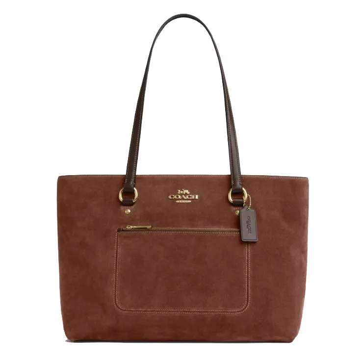 A brown suede Coach tote bag with dual leather handles, featuring a front zip pocket and the Coach logo in gold-tone hardware.