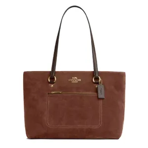 A brown suede Coach tote bag with dual leather handles, featuring a front zip pocket and the Coach logo in gold-tone hardware.