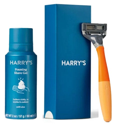 A shaving set featuring Harry's Foaming Shave Gel with aloe and an orange-handled razor next to the packaging.