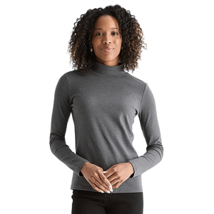 A woman is wearing a gray turtleneck long-sleeve top paired with black pants, standing against a plain background.