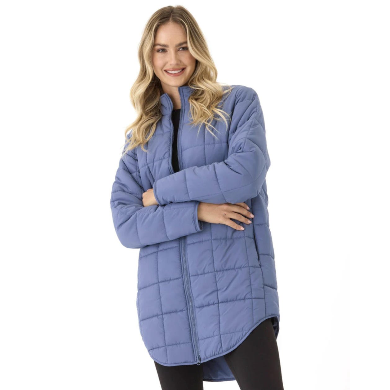 A woman wearing a blue, quilted, long puffer jacket with a front zipper, paired with black leggings.