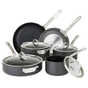 A set of nonstick cookware including various pots and pans with glass lids, featuring stainless steel handles.