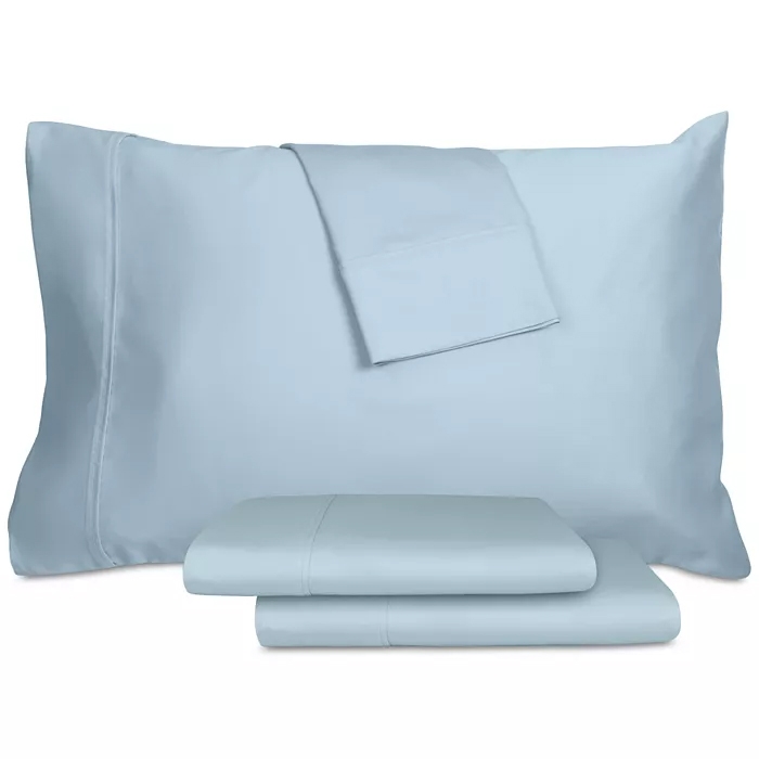 Light blue bed sheets and pillowcases neatly arranged, consisting of a flat sheet, fitted sheet, and two pillowcases.