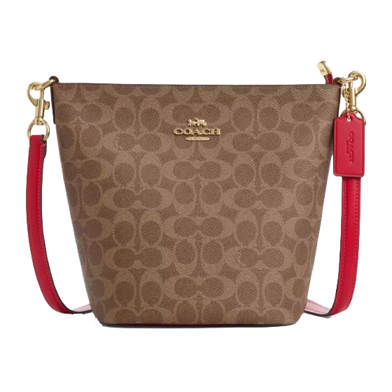 A Coach handbag with a signature brown monogram pattern and a red leather strap. The bag features gold-tone hardware and a Coach logo tag.