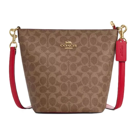 A Coach handbag with a signature brown monogram pattern and a red leather strap. The bag features gold-tone hardware and a Coach logo tag.