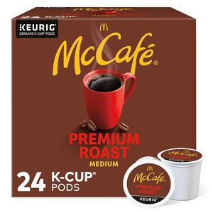 A box of McCafe Premium Roast Medium Keurig K-Cup coffee pods, with a total count of 24 pods, is displayed with a red mug and coffee beans.