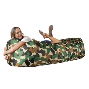 A woman is reclining on a camouflaged inflatable air lounger.