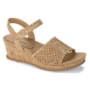 Beige wedge sandal featuring a cork-like finish, adjustable ankle strap, woven toe strap, and a moderate heel.