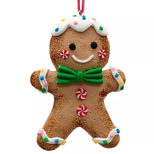 A gingerbread man ornament with a white icing hat, colorful sprinkles, a green bow tie, peppermint buttons, and colorful frosting accents on arms and legs, hanging by a red string.