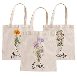 Three beige tote bags with floral designs and personalized names: Amanda, Emily, and Angela. Each bag features a different flower illustration in the center.