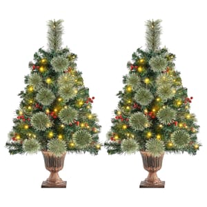 Two identical decorated artificial Christmas trees with lights and red berry ornaments.