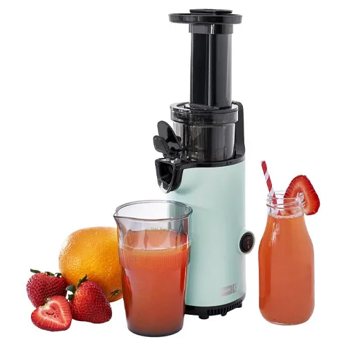 A vertical juicer with a light blue body is surrounded by fresh strawberries and an orange, alongside a glass and a bottle of freshly made juice.