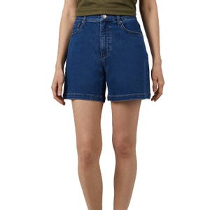 Blue high-waisted denim shorts paired with a green top.