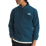 A person is wearing a blue The North Face quarter-zip fleece top with the brand's logo on the left chest. The top is layered over a white shirt and paired with dark pants.