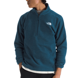 A person is wearing a blue The North Face quarter-zip fleece top with the brand's logo on the left chest. The top is layered over a white shirt and paired with dark pants.