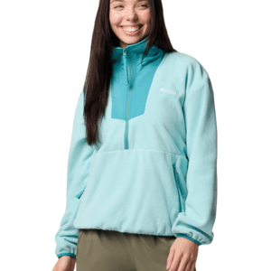 A woman is wearing a light blue and teal fleece pullover with a half-zip design, featuring a front kangaroo pocket, by Columbia.