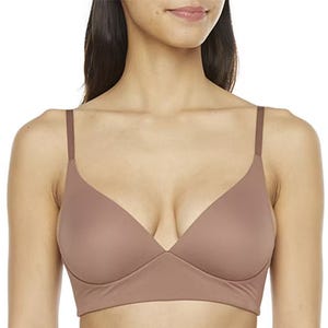 A woman wearing a plain brown bralette with adjustable straps.