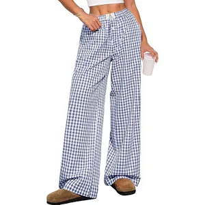 Wide-leg checkered pants paired with a cropped white top and brown slip-on shoes, with a person holding a cup.