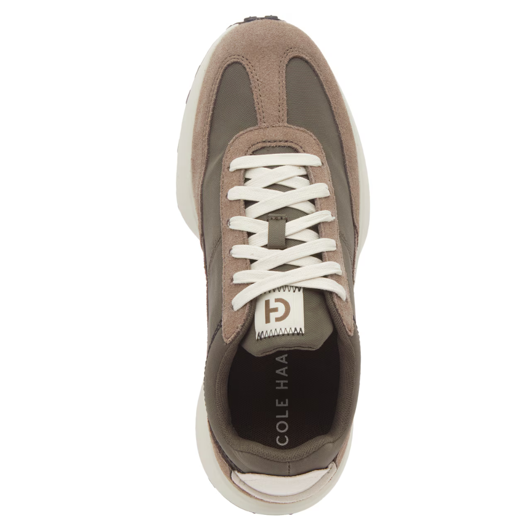 Top-down view of a Cole Haan men's sneaker with brown suede and green fabric, white laces, and a white sole.