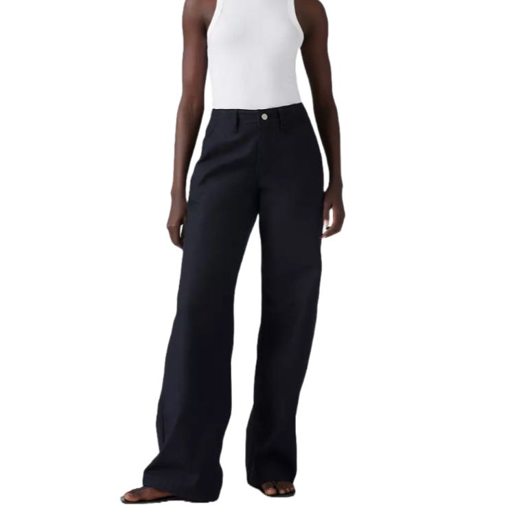 A person is wearing high-waisted, wide-leg black pants paired with a white sleeveless top and sandals.