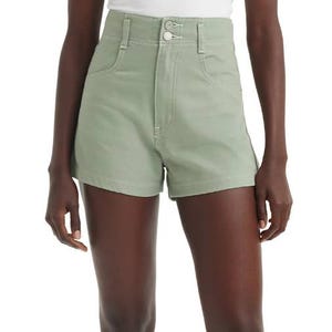 High-waisted, light green Levi's shorts featuring a zipper and button closure, front pockets, and a tailored fit.