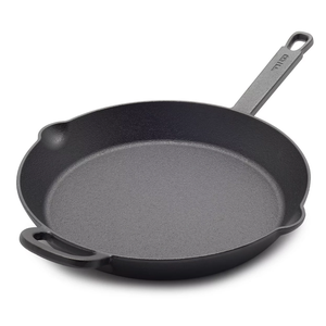 Cast iron skillet with a long handle and an additional helper handle, featuring dual pour spouts.