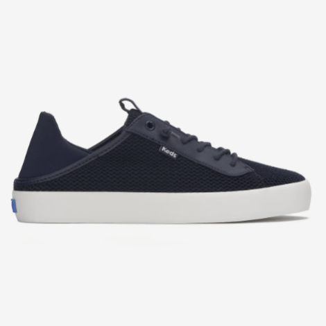 A navy blue low-top sneaker with a white sole and mesh upper, featuring laces and a subtle logo tab on the side.