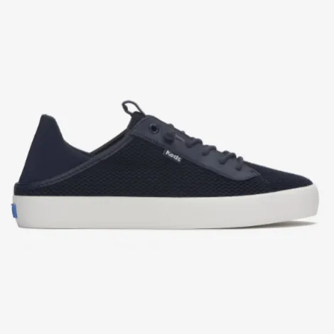 A navy blue low-top sneaker with a white sole and mesh upper, featuring laces and a subtle logo tab on the side.