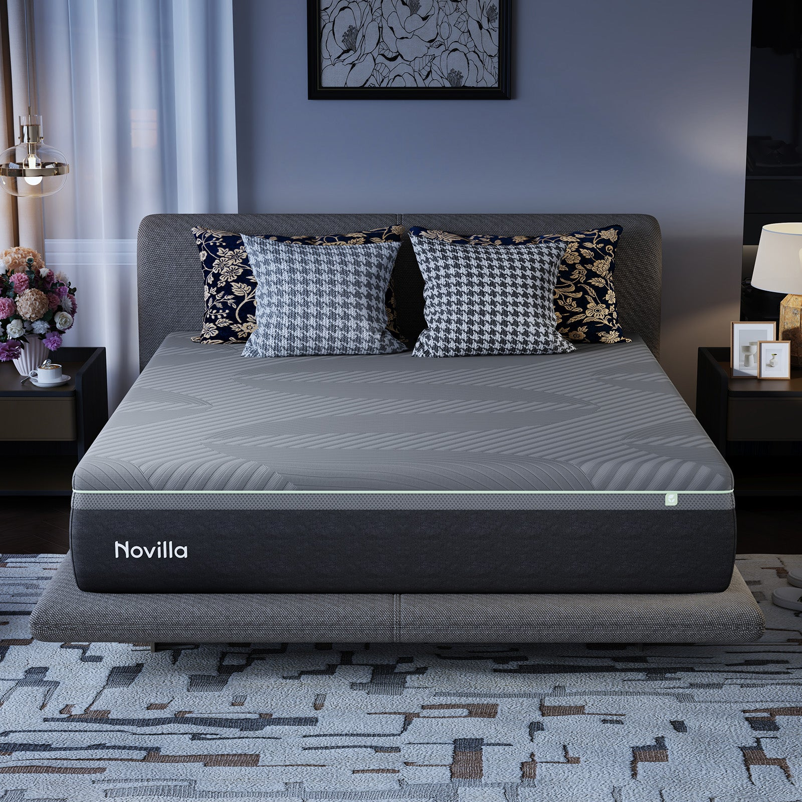 Novilla mattress on a bed with patterned pillows, surrounded by decor including a nightstand with a lamp and a vase of flowers.