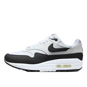 Nike Air Max 1 features a white and light gray upper with a black mudguard, white midsole, and visible Air unit. It has a black Swoosh and a lace-up closure.