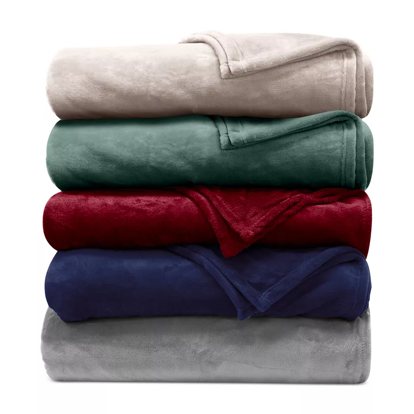 A stack of five fleece blankets in various colors: beige, green, red, navy blue, and gray.