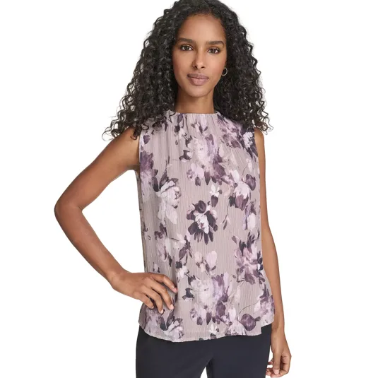 Sleeveless blouse with a floral pattern in shades of purple and lavender, paired with dark trousers.