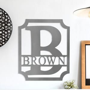 Wall decal with the letter \“B\“ inside a shield silhouette, featuring the word \“BROWN\“ below, displayed on a home wall.