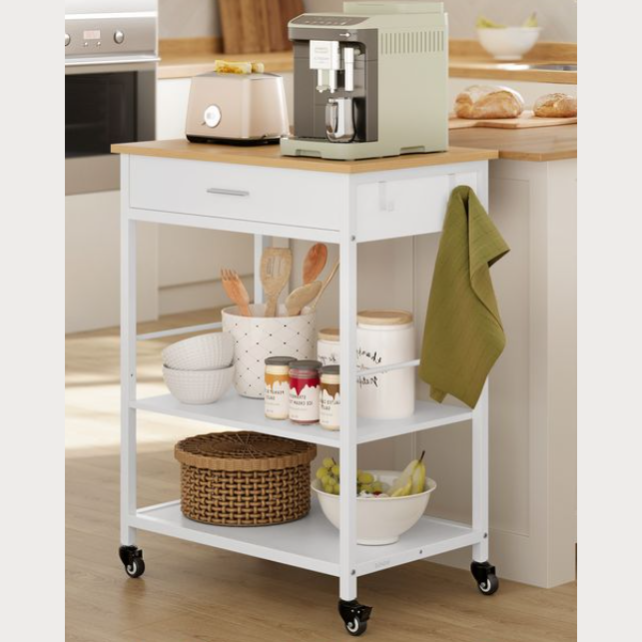 A white kitchen cart with a wooden top holds a coffee machine, a drawer, and two shelves featuring utensils, jars, a woven basket, and a bowl of bananas, with a green towel hanging on the side. The cart is on wheels for mobility.