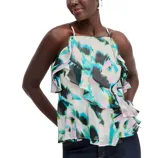 A woman is wearing a colorful, abstract-patterned sleeveless top with ruffled layers and thin straps. The top features shades of blue, green, and pink.