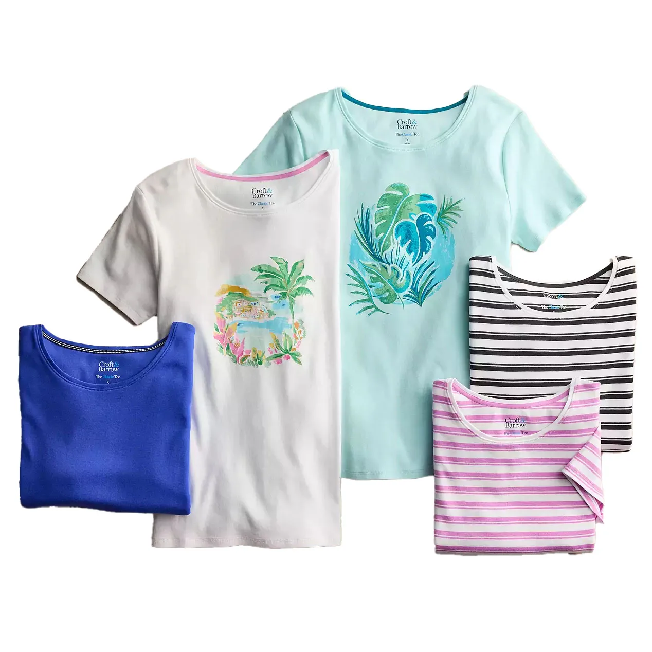 A collection of Croft & Barrow crewneck tees featuring vibrant designs and patterns, including palm trees, leaves, stripes in black and white, and pink and white. Colors include blue, white, and light blue.