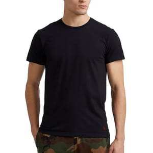 A man is wearing a black, short-sleeved Ralph Lauren t-shirt with a red logo on the chest, paired with camo-print pants.