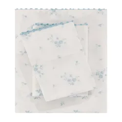 A set of bed sheets with a light blue floral pattern on a white background, featuring scalloped blue edges.