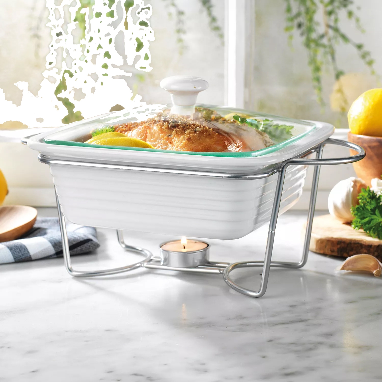 White ceramic chafing dish with a lid placed on a metal stand, kept warm by a tealight candle underneath.