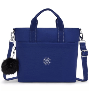 Blue tote bag with dual handles, detachable crossbody strap, front pocket, and a fluffy black charm. Features a circular logo design.