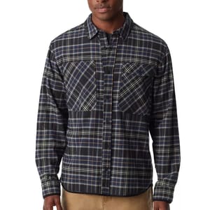 A man wearing a blue plaid long-sleeve flannel shirt with two chest pockets.