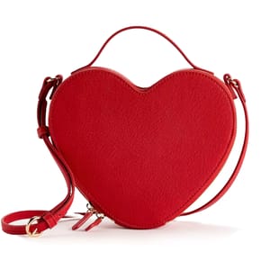 A red, heart-shaped handbag with a textured surface, featuring a handle and an adjustable shoulder strap. The bag has gold hardware and a zipper closure at the top.