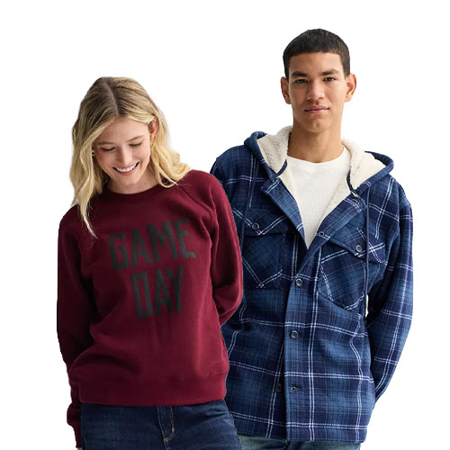A woman wears a maroon \“GAME DAY\“ sweater and blue jeans, while a man wears a blue plaid hooded jacket over a white shirt.