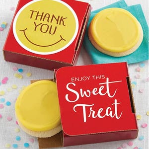 Two yellow frosted cookies are partially enclosed in red boxes with text \“THANK YOU\“ on one and \“ENJOY THIS Sweet Treat\“ on the other, surrounded by confetti.