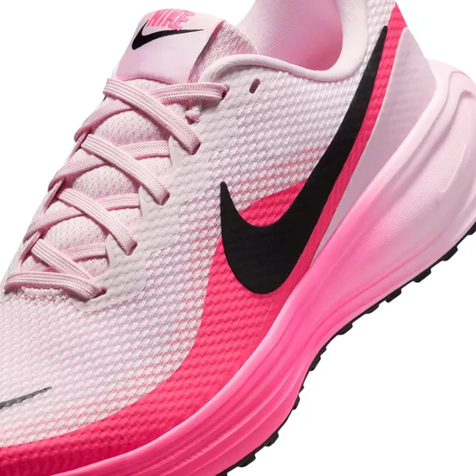 A pink and white Nike running shoe featuring a bold black swoosh and laces, with a gradient pink sole.