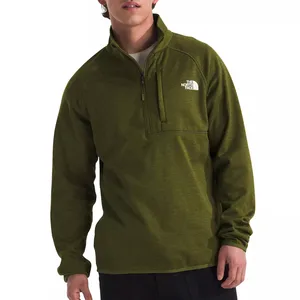 A man wears an olive green North Face half-zip pullover with a chest pocket and logo on the front.