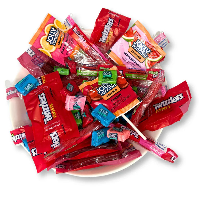 A bowl filled with Jolly Rancher hard candies, lollipops, and Twizzlers Twists, featuring flavors like cherry, watermelon, green apple, and blue raspberry.
