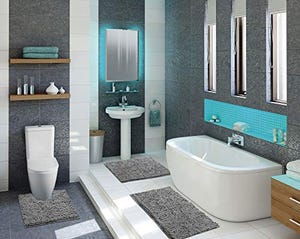 Three matching shaggy rugs in a bathroom setting: one around the toilet base, one in front of the sink, and a larger rug in front of the bathtub, all in a grey and white color scheme.