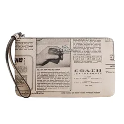 A Coach wristlet features a vintage newspaper print design with a prominent Coach Leatherware logo and a strap for easy carrying.