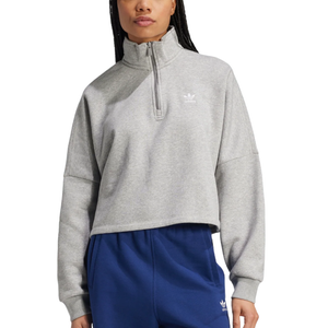 A person wearing a gray Adidas quarter-zip pullover top with a small trefoil logo and blue Adidas pants.